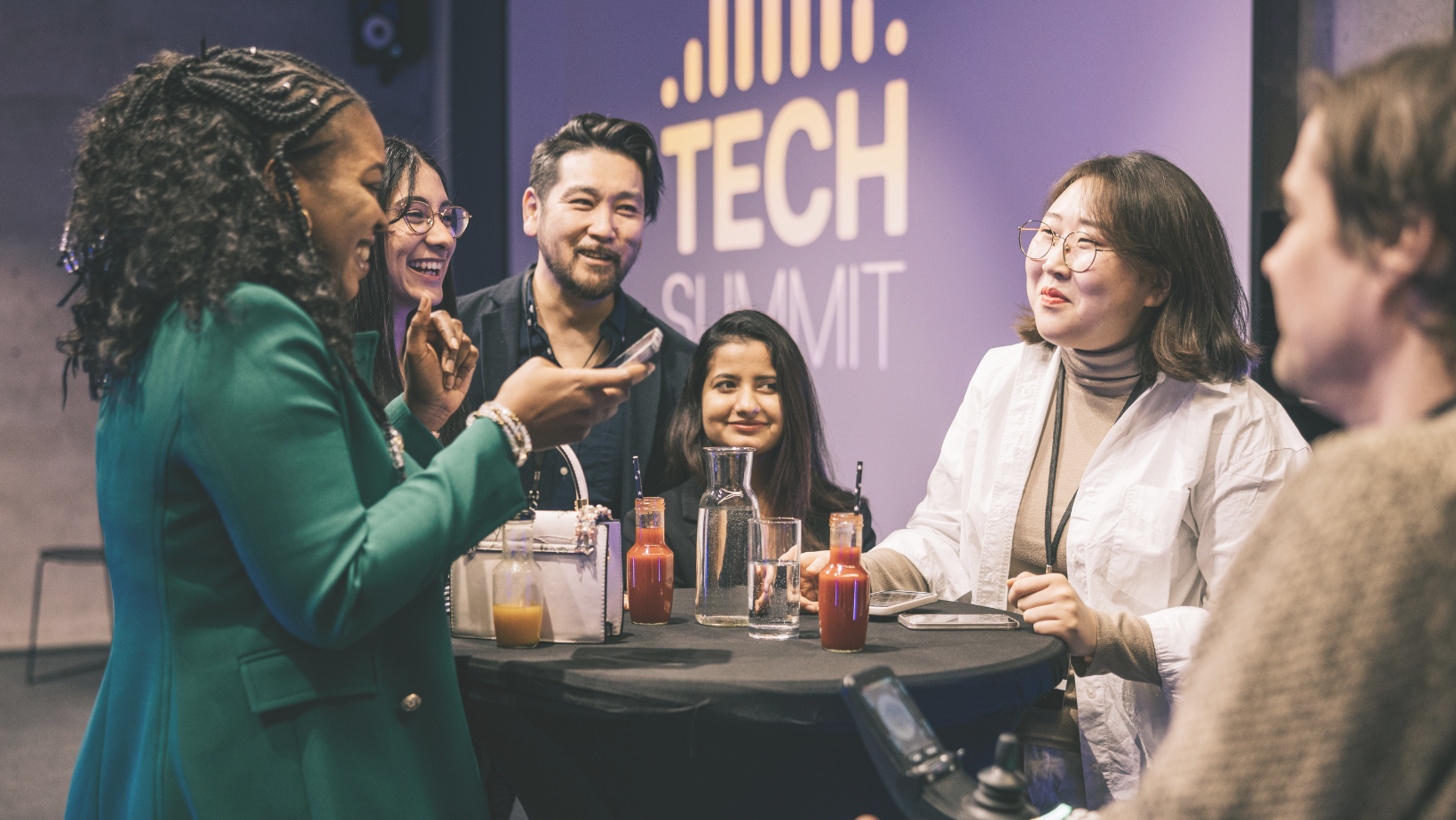 Group of people at work event talking around a table